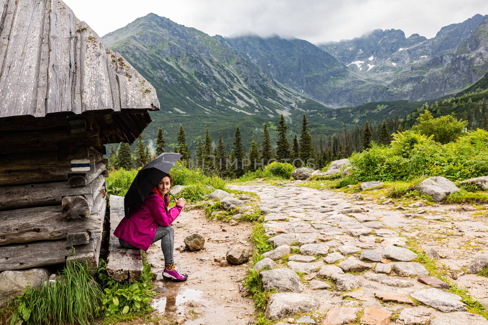 Woman sitting in the rain by sheperd house in Tatra mountain, Po by mkenwoo