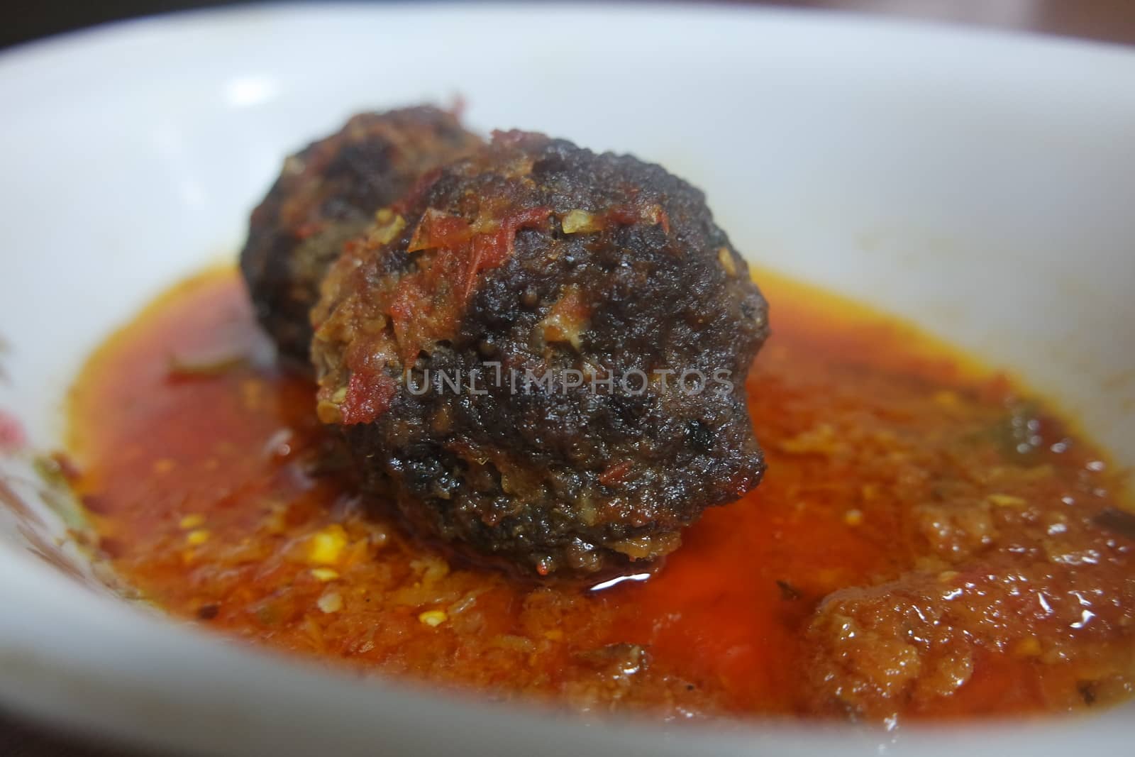 Closeup view with selective focus of meatball dish.Top view of meat balls or meat kofta curry in masala gravy in a ceramic plate.