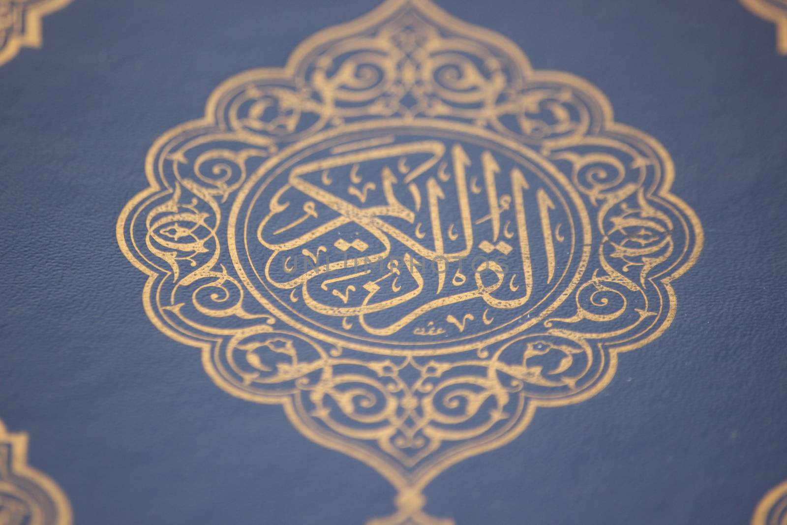 Closeup shot of Islamic Book Quran with golden arabic calligraphy by Photochowk