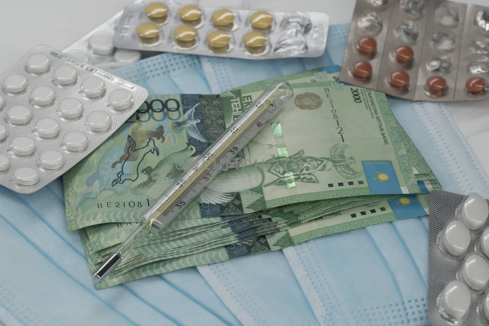 Thermometer, tablet, medical mask and tenge money are on the table. Increase in the price of medicines in Kazakhstan in tenge KZT. Kazakhstan is quarantined due to the coronavirus and flu epidemic.