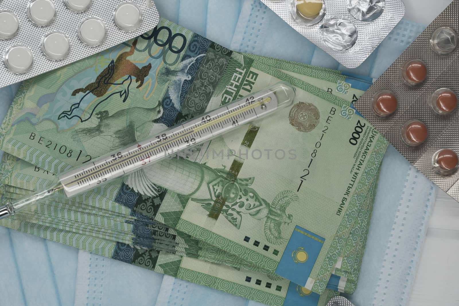 Thermometer, tablet, medical mask and tenge money are on the tab by YevgeniySam