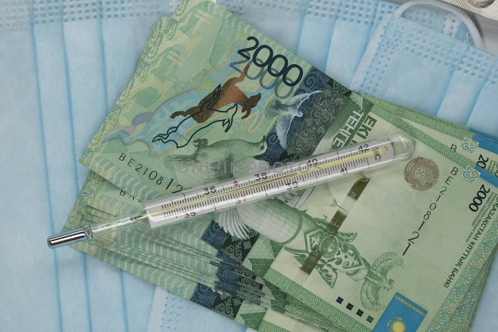 Thermometer, tablet, medical mask and tenge money are on the table. Increase in the price of medicines in Kazakhstan in tenge KZT. Kazakhstan is quarantined due to the coronavirus and flu epidemic.