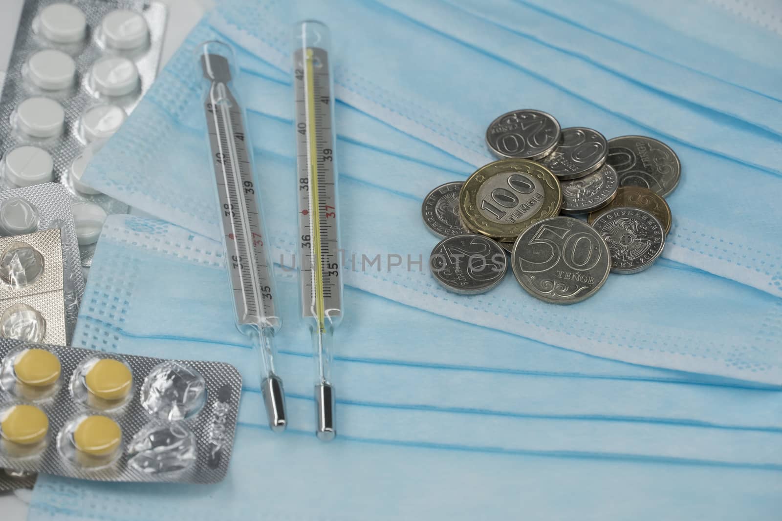 Thermometer, tablet, medical mask and tenge money are on the tab by YevgeniySam