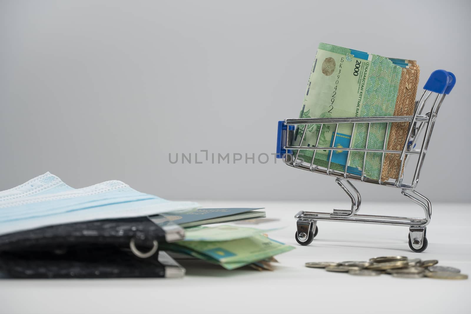 Quarantine and border closure in Kazakhstan for coronavirus. On the table are money in tenge with medical face masks, a globe, a card and a passport. Closing borders and leaving for Kazakhstan.