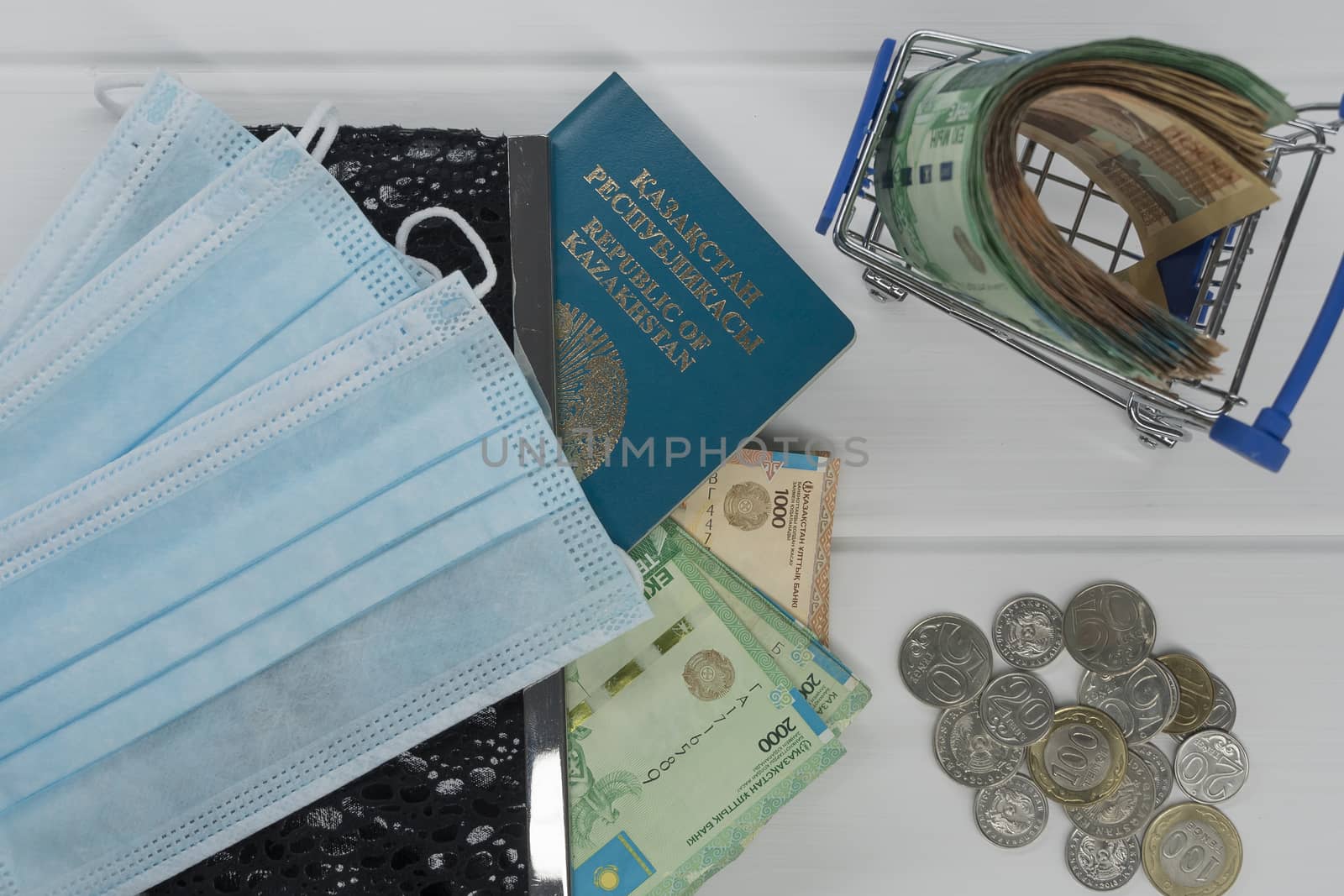 Quarantine and border closure in Kazakhstan for coronavirus. On the table are money in tenge with medical face masks, a globe, a card and a passport. Closing borders and leaving for Kazakhstan.