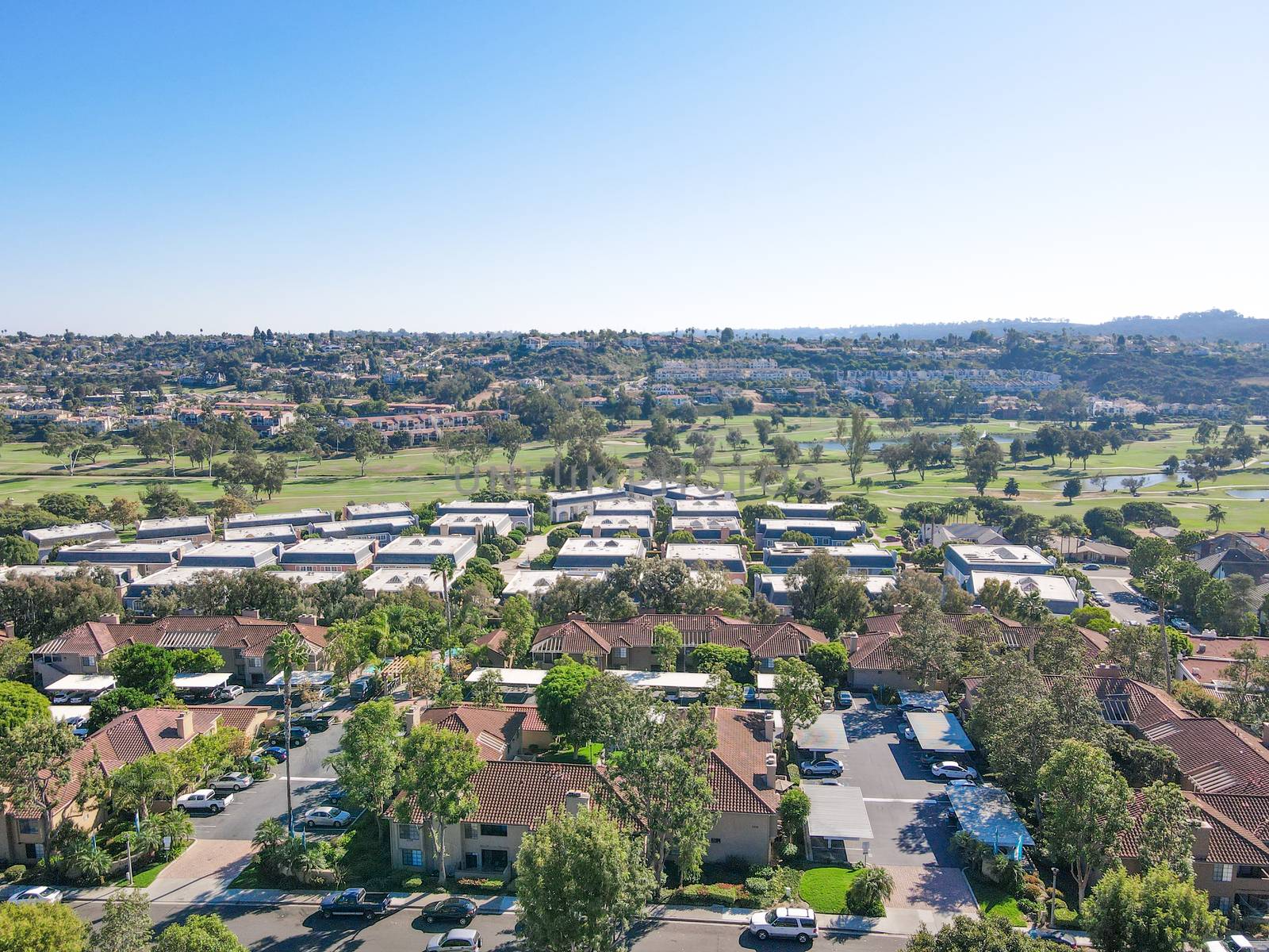 Aerial view of houses and condos with golf on the background in Carlsbad by Bonandbon