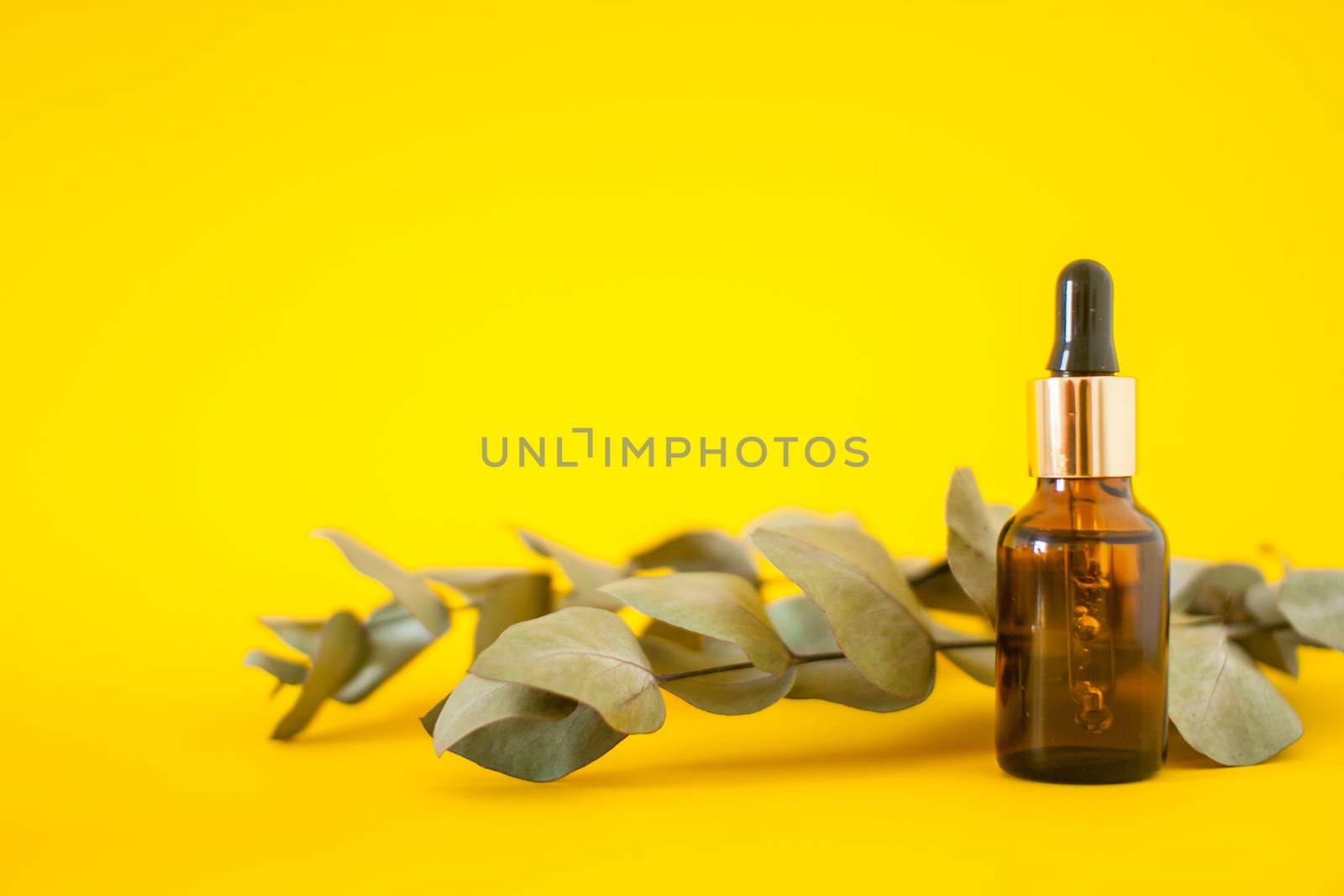 Cosmetic bottles with serum on a yellow background. Cosmetology and beauty concept. by malyshkamju