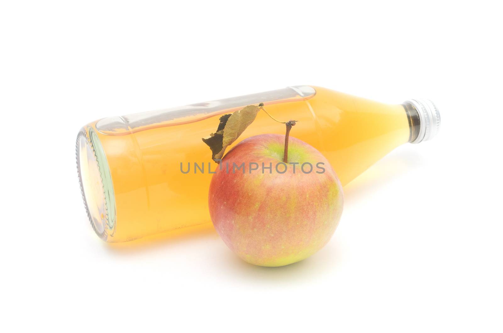 One whole apple with leaf and a lying bottle of apple cider vinegar isolated on white background. by andre_dechapelle