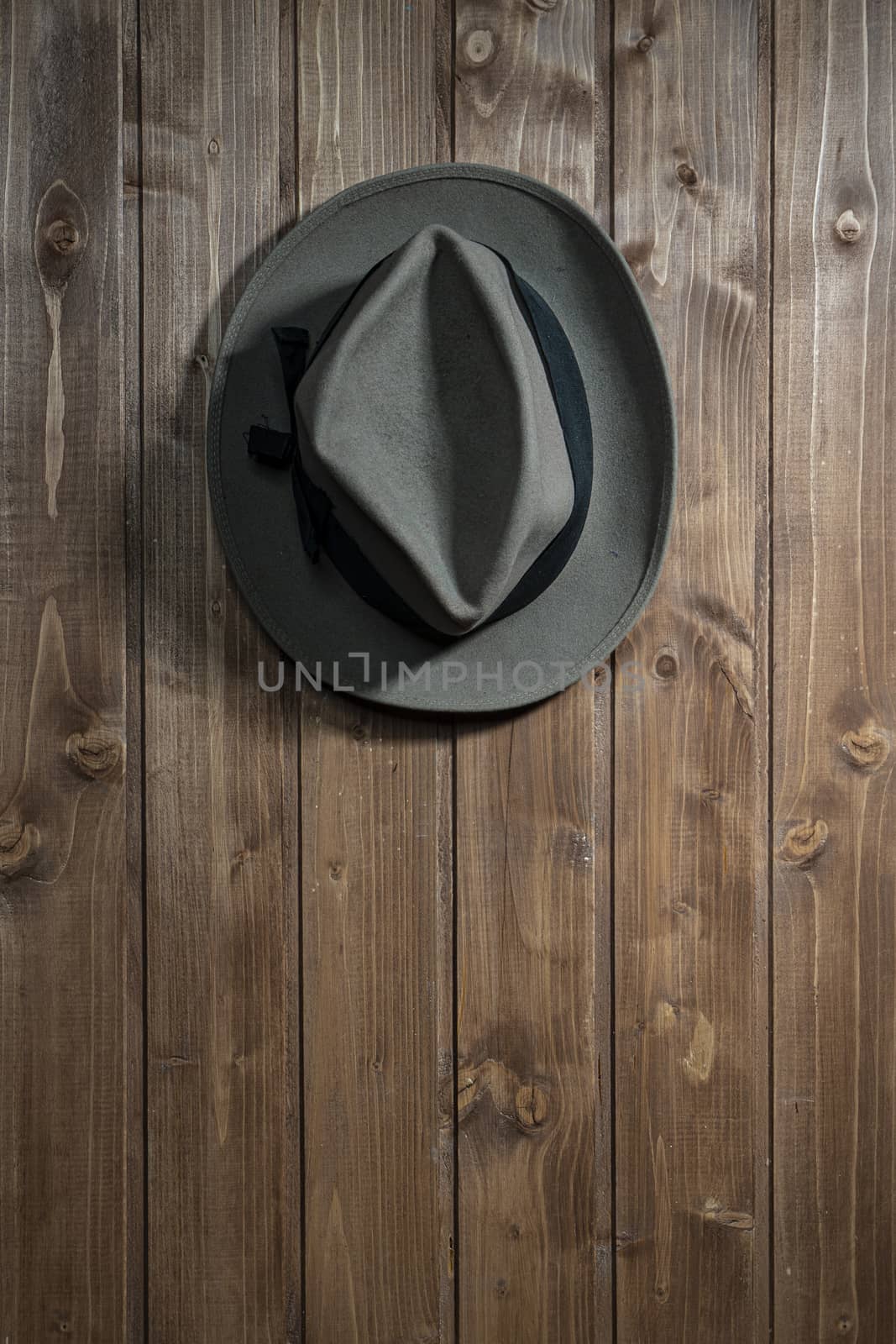 an old hat hanging on a wooden wall