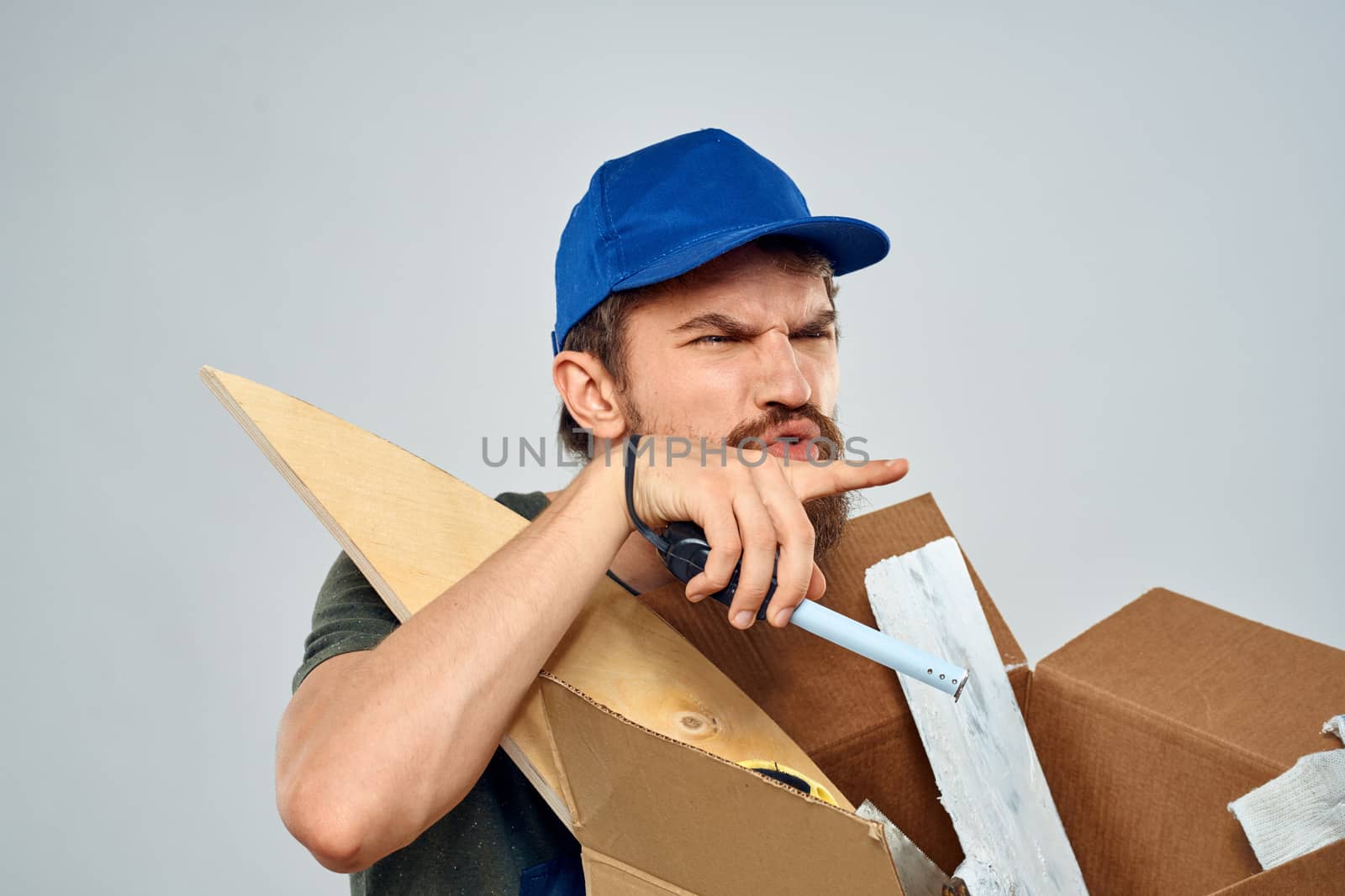 man in work uniform with box in hands tools lifestyle light background by SHOTPRIME