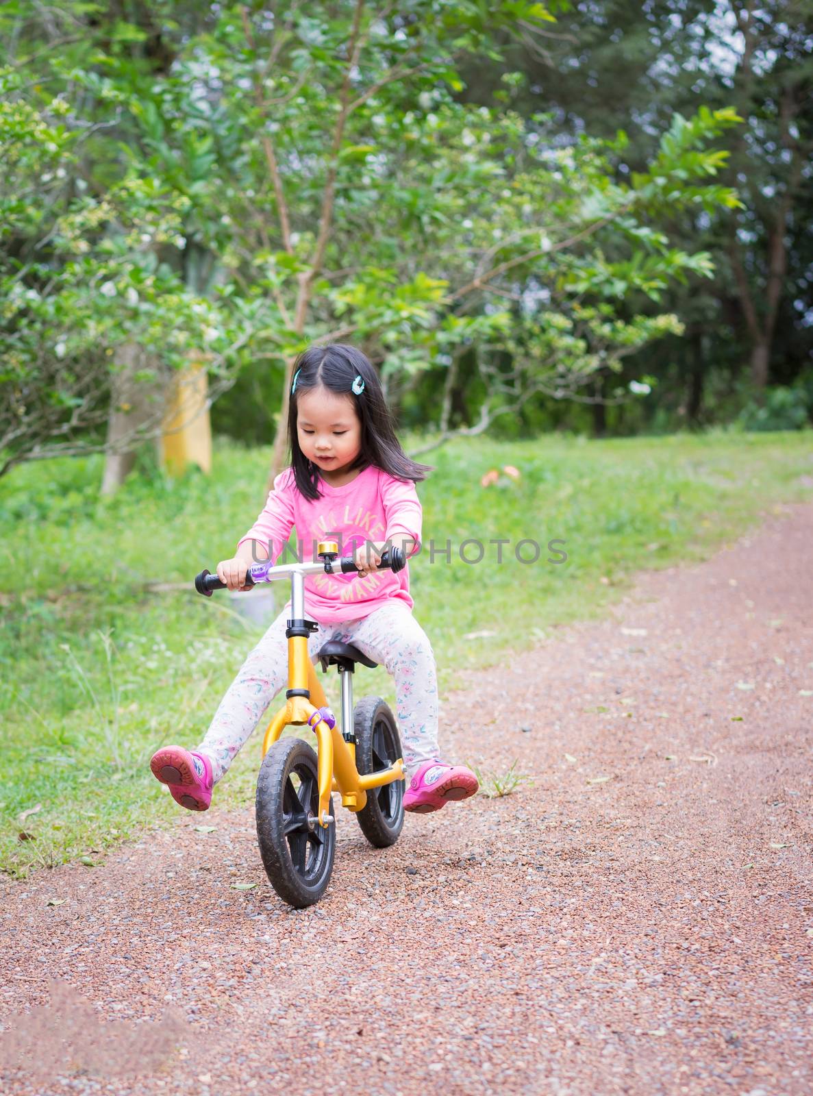 Little girl learns to riding balance bike on slope in the park by domonite