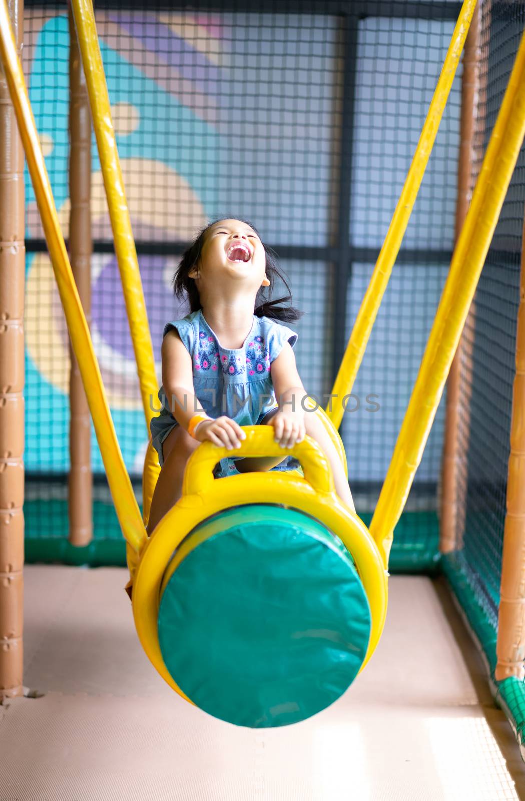 Asian little girl enjoys playing in a children playground by domonite