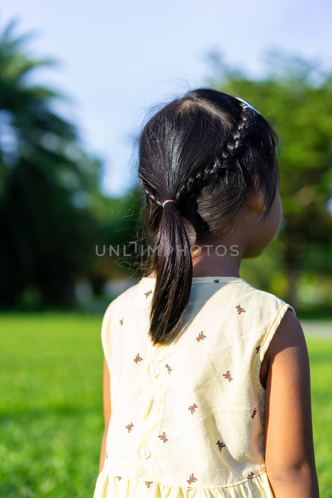 Back view of adorable little girl with beautiful hair walking in by domonite