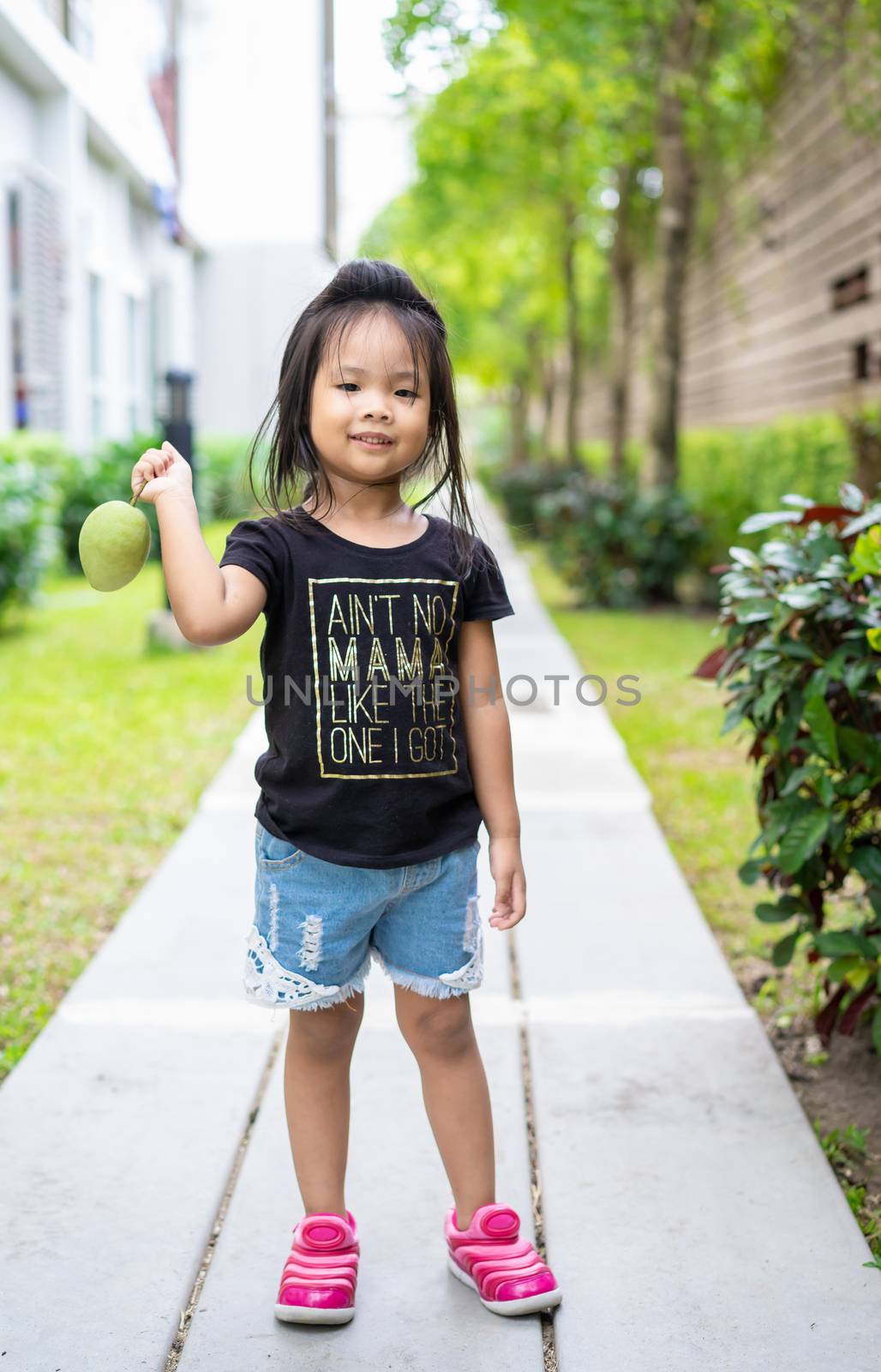 Little girl with a mango in her hand by domonite