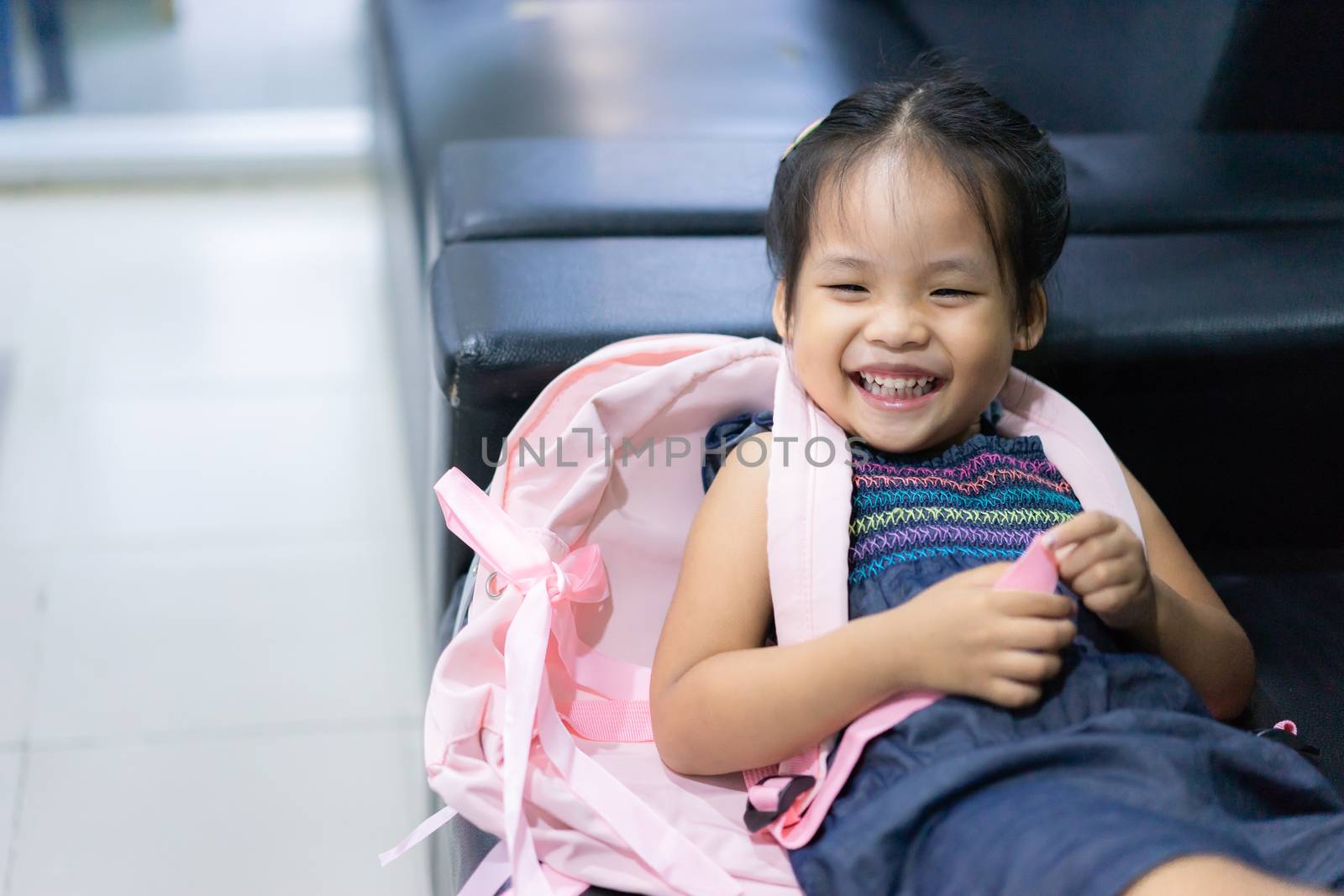 little girl with backpack lying on sofa ready back to school