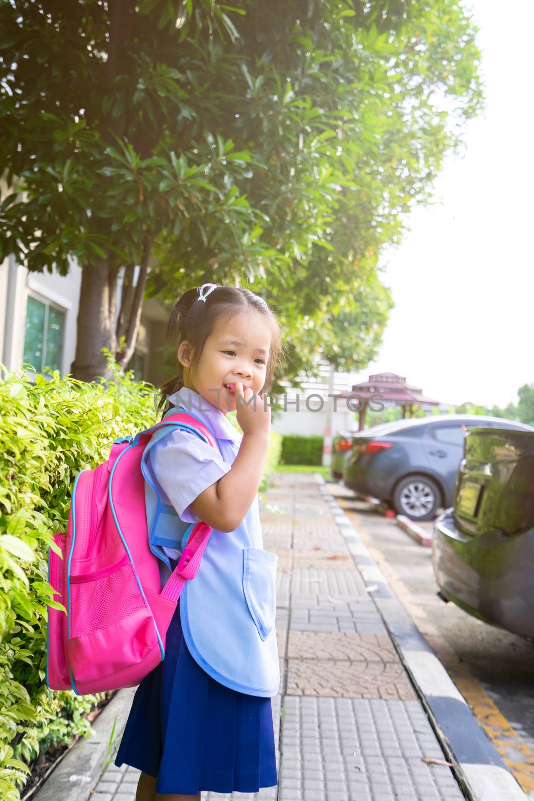 little girl with backpack walking in car park ready back to school