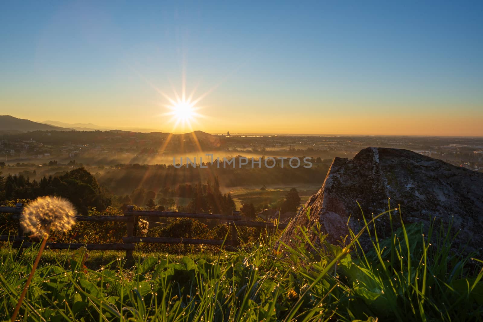 Hilly landscape at sunrise on an autumn morning with a light mist on the horizon