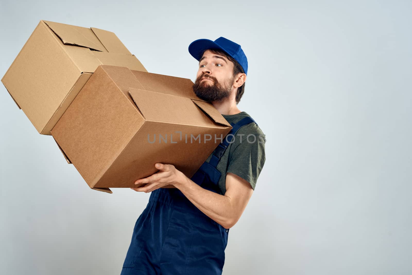 Man in working uniform with boxes in hands delivery loading lifestyle. High quality photo