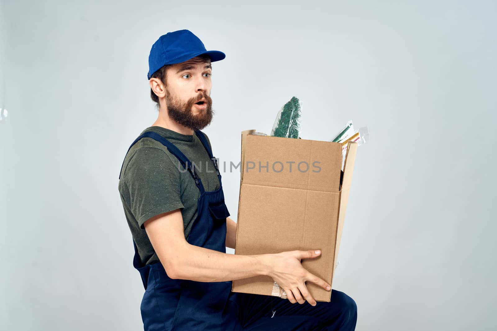 Man in working uniform with boxes in hands delivery loading lifestyle by SHOTPRIME