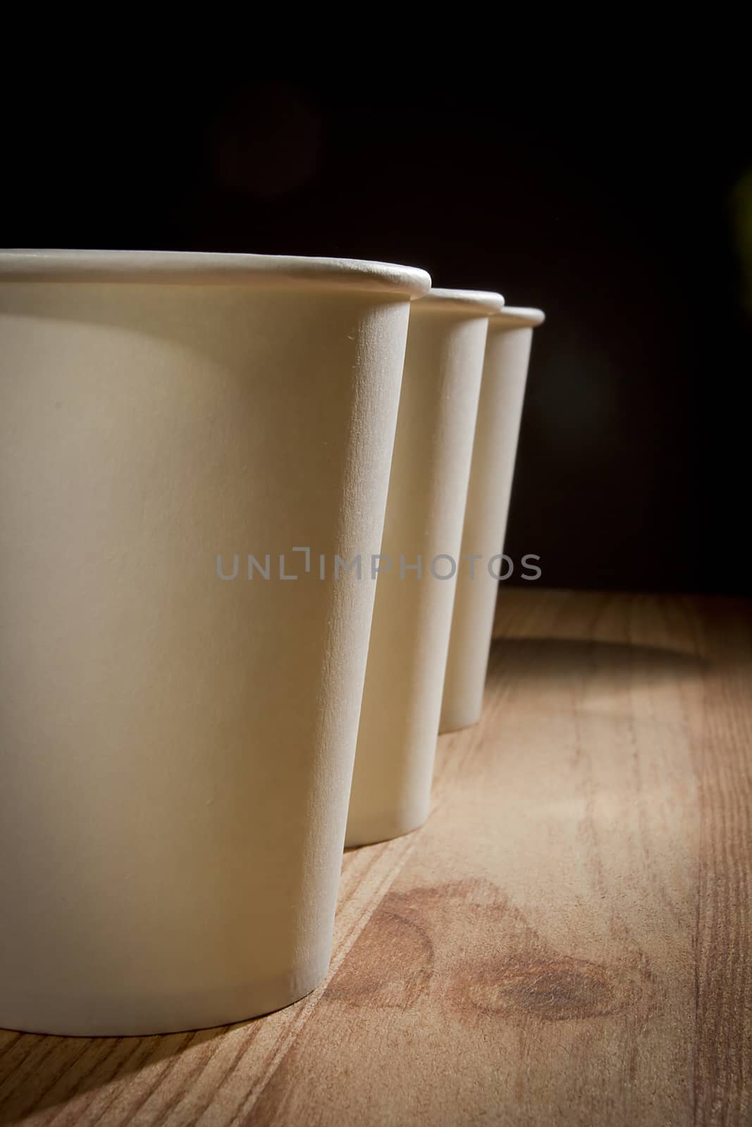 White paper disposable cups on wooden table