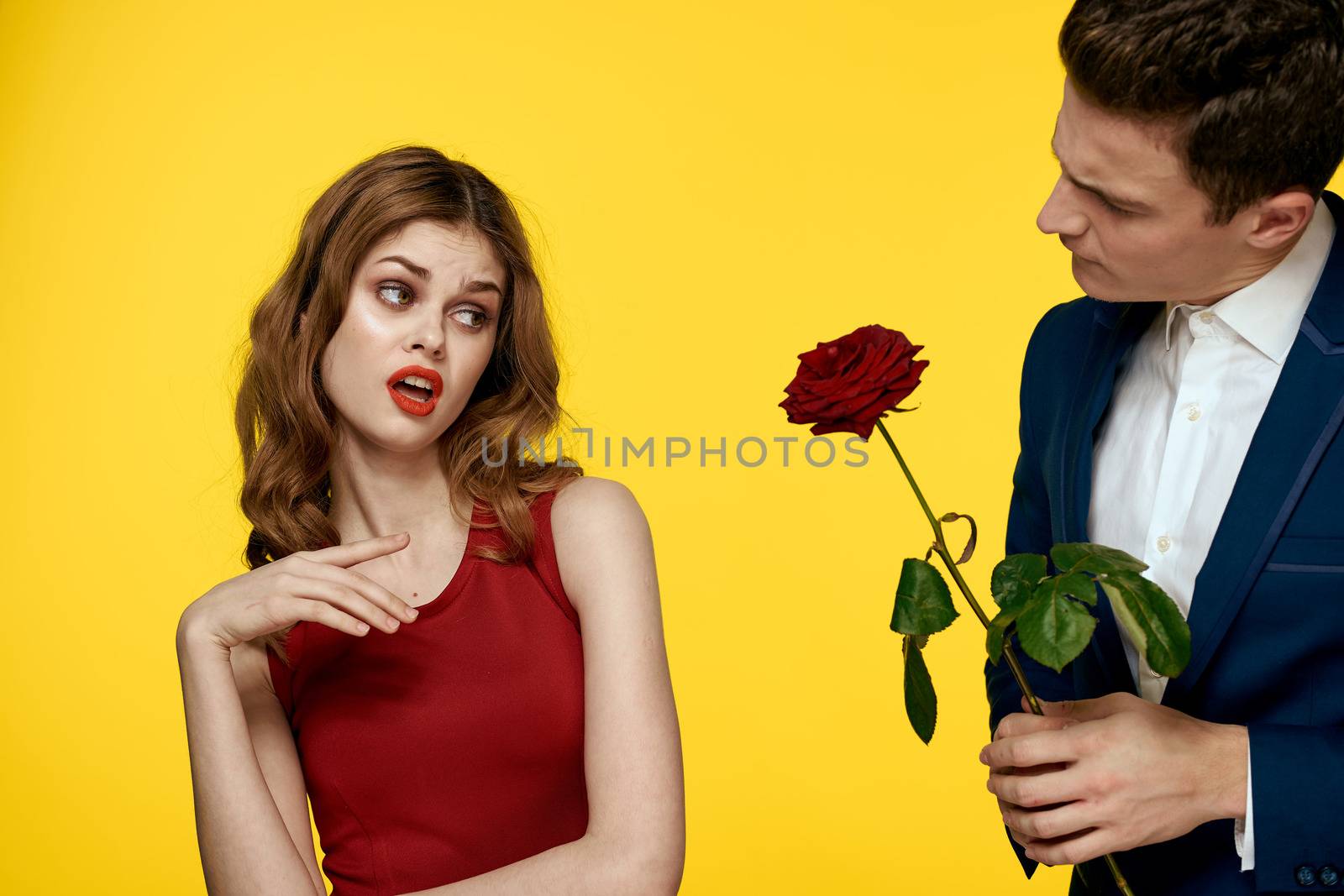 Young charming couple rose relationship romance gift as a lifestyle yellow isolated background. High quality photo