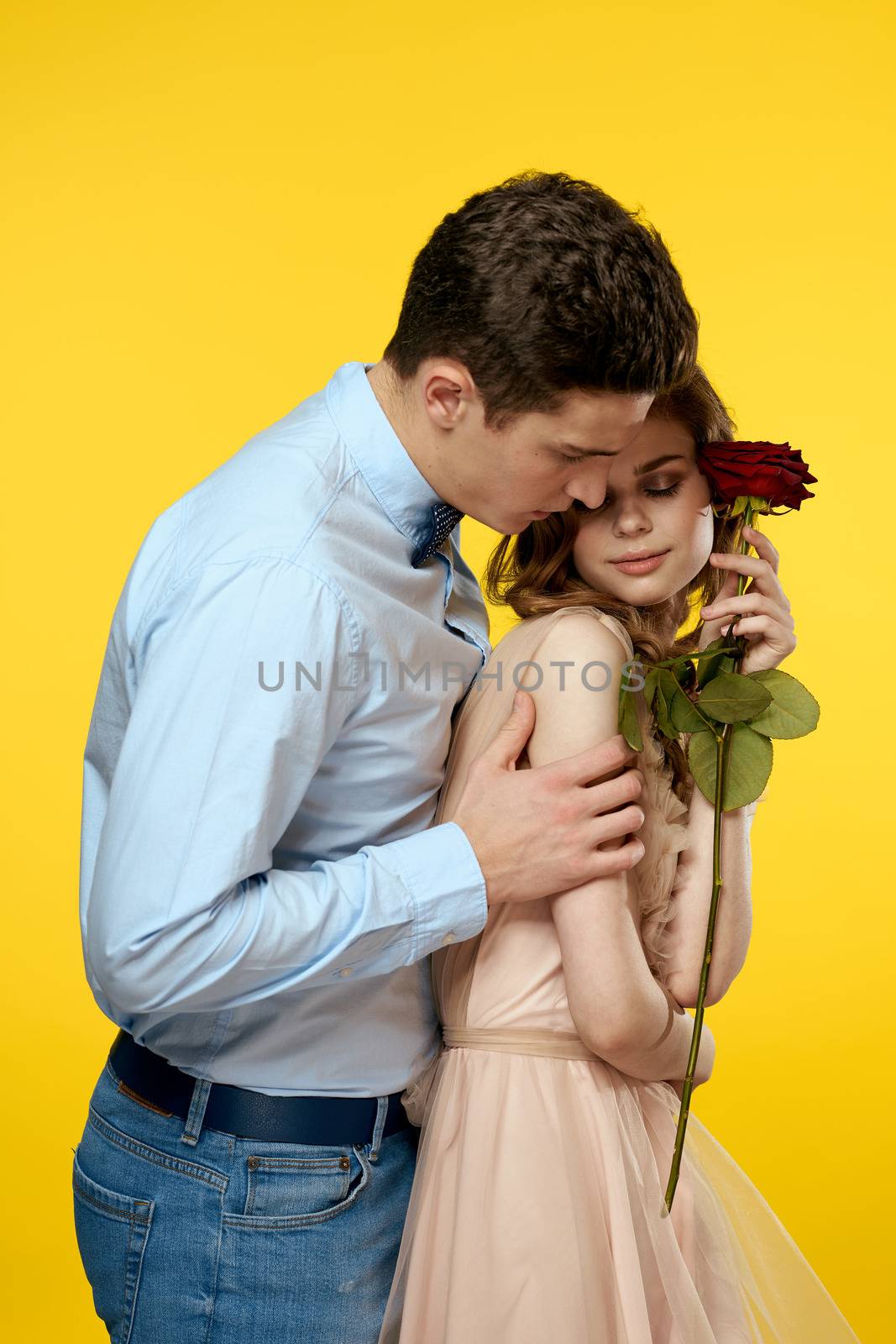 Enamored man and woman with red rose on yellow background cropped view close-up romance. High quality photo