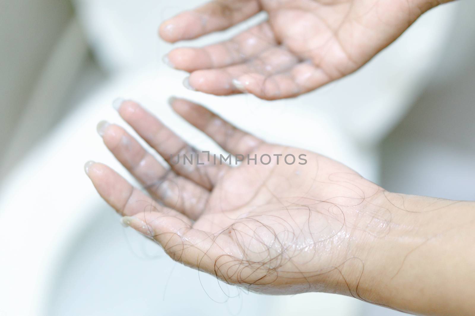 Closeup Hair loss on woman hand in the bathroom by pt.pongsak@gmail.com
