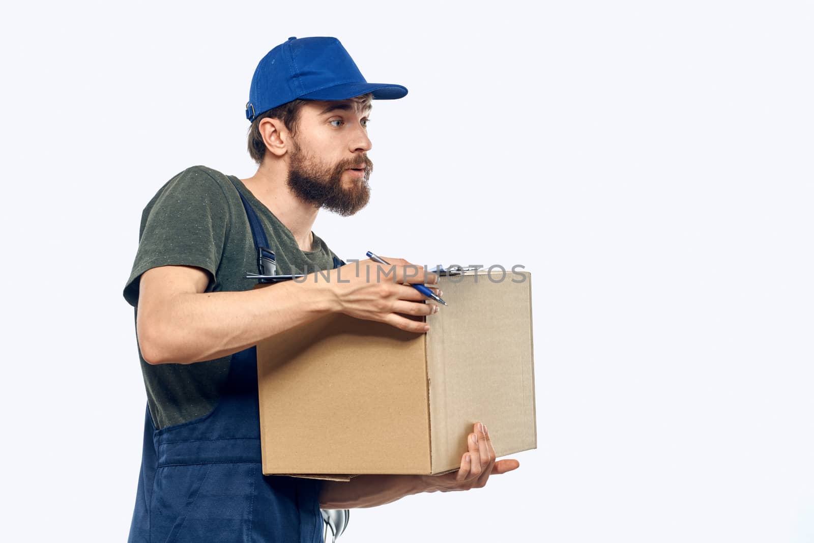 Working male courier with box in hand documents delivery service light background. High quality photo