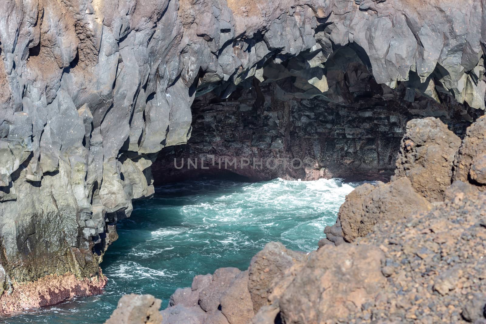 Rocky coastline Los Hervideros in the south west of canary island Lanzarote, Spain with rough sea, lava caves and multi colored volcanic rocks