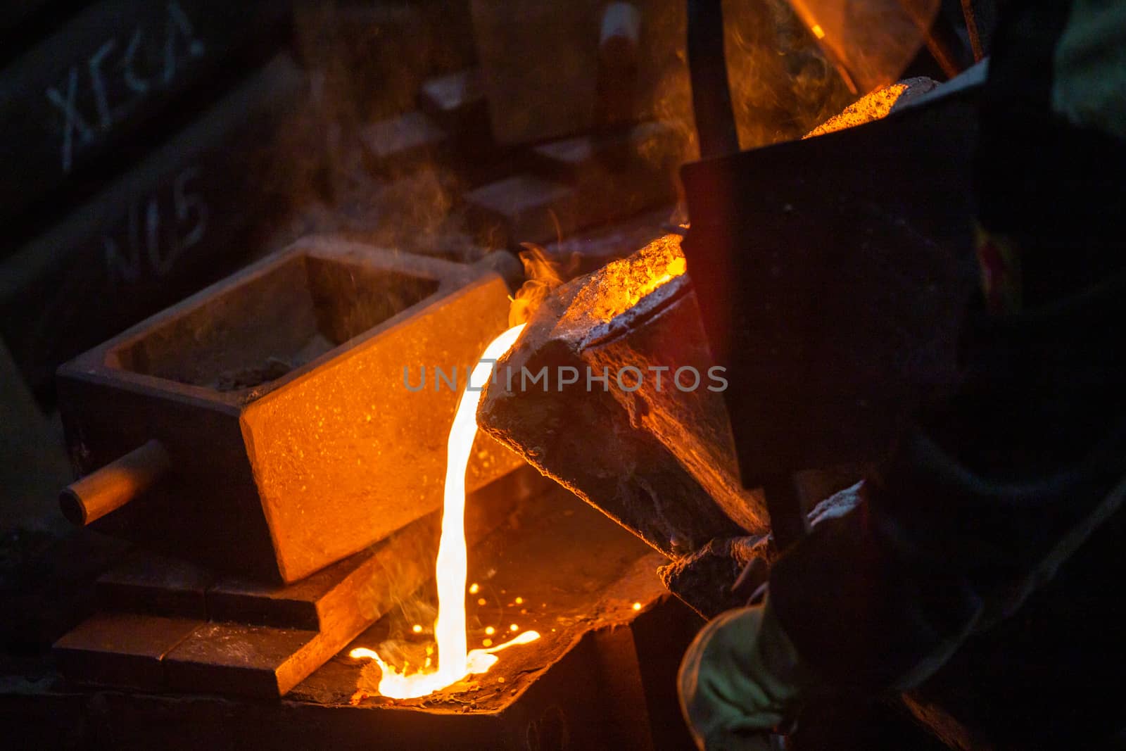 Close-up view of industrial chill casting with selective focus. The process of for filling out mold with molten metal.
