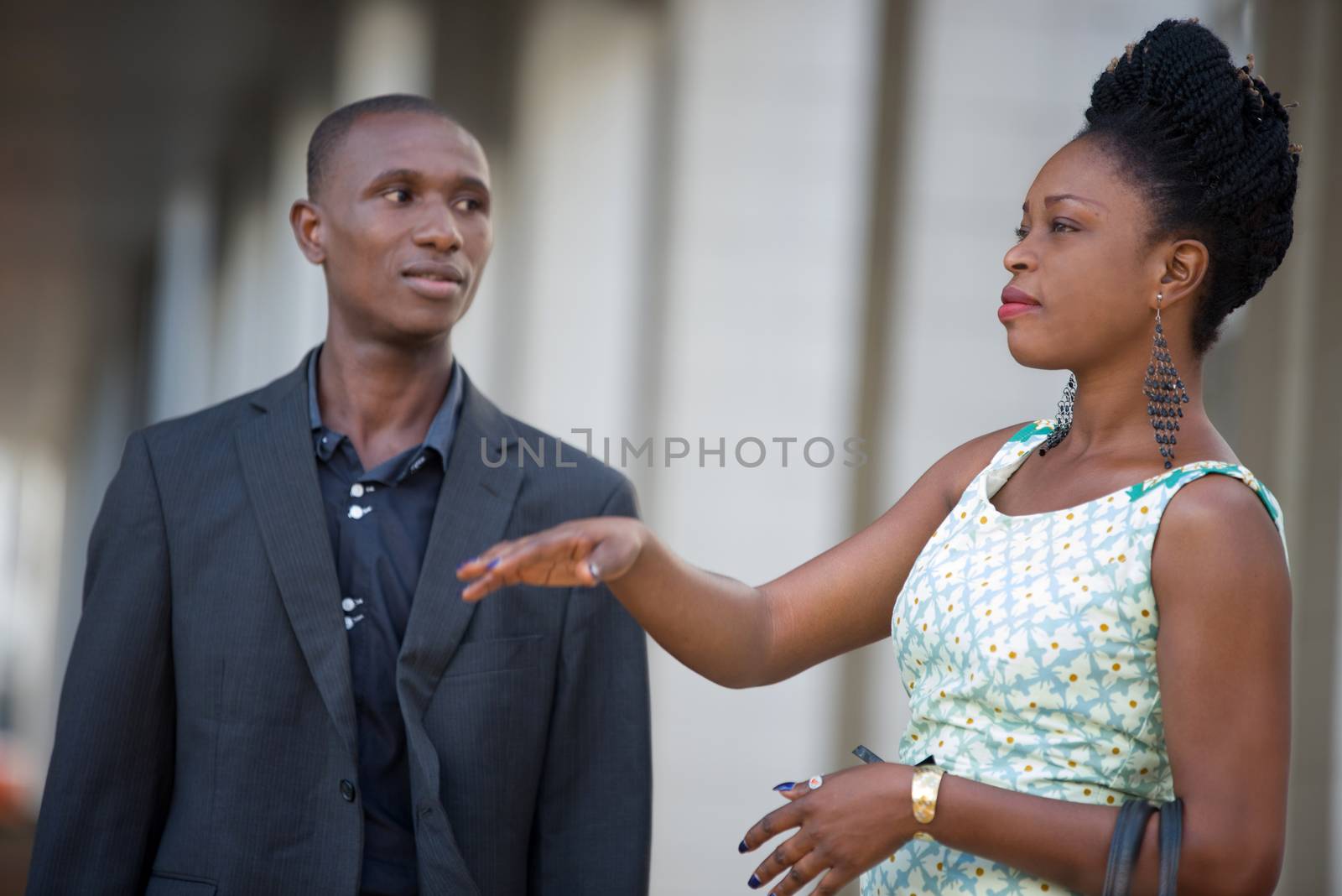 young business people standing together discuss their work where the man looks attentively at his colleague.