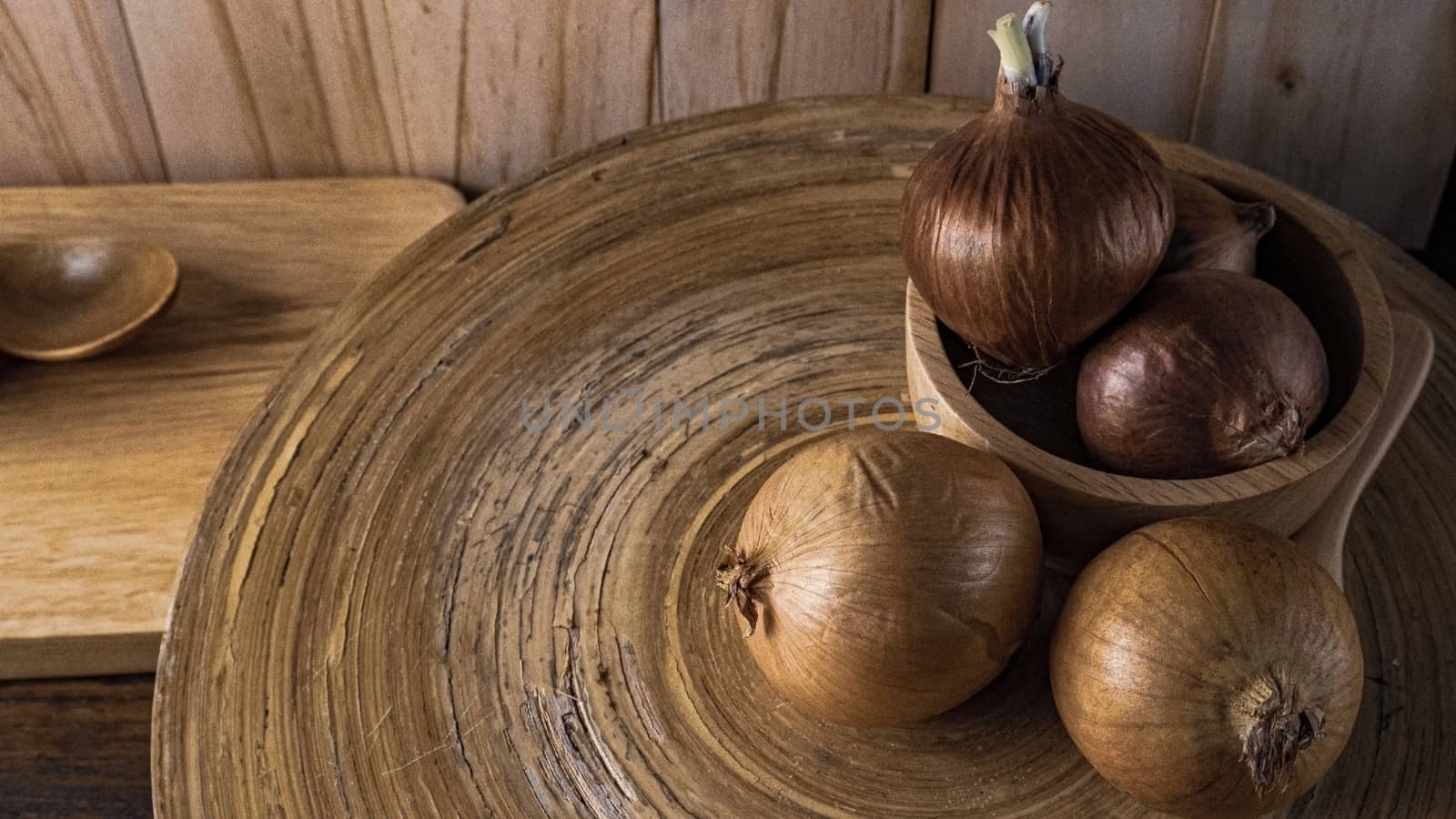 The onion in wood bowl  on wood table for food content.