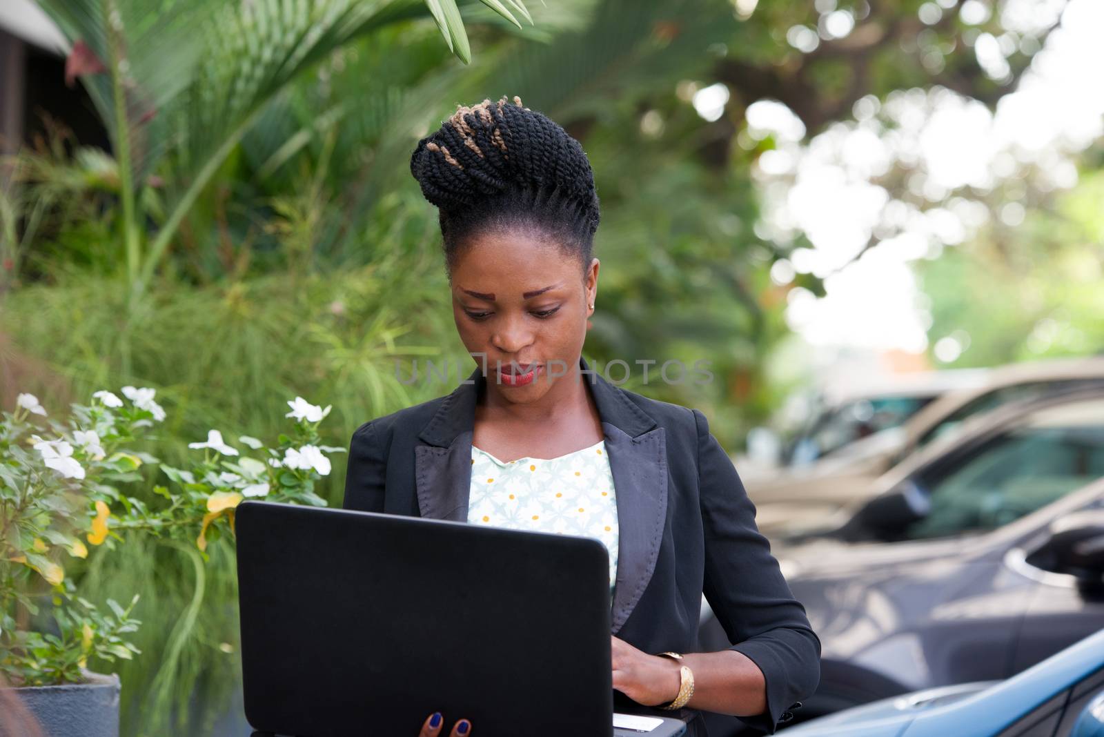 young happy businesswoman with a laptop standing outside.