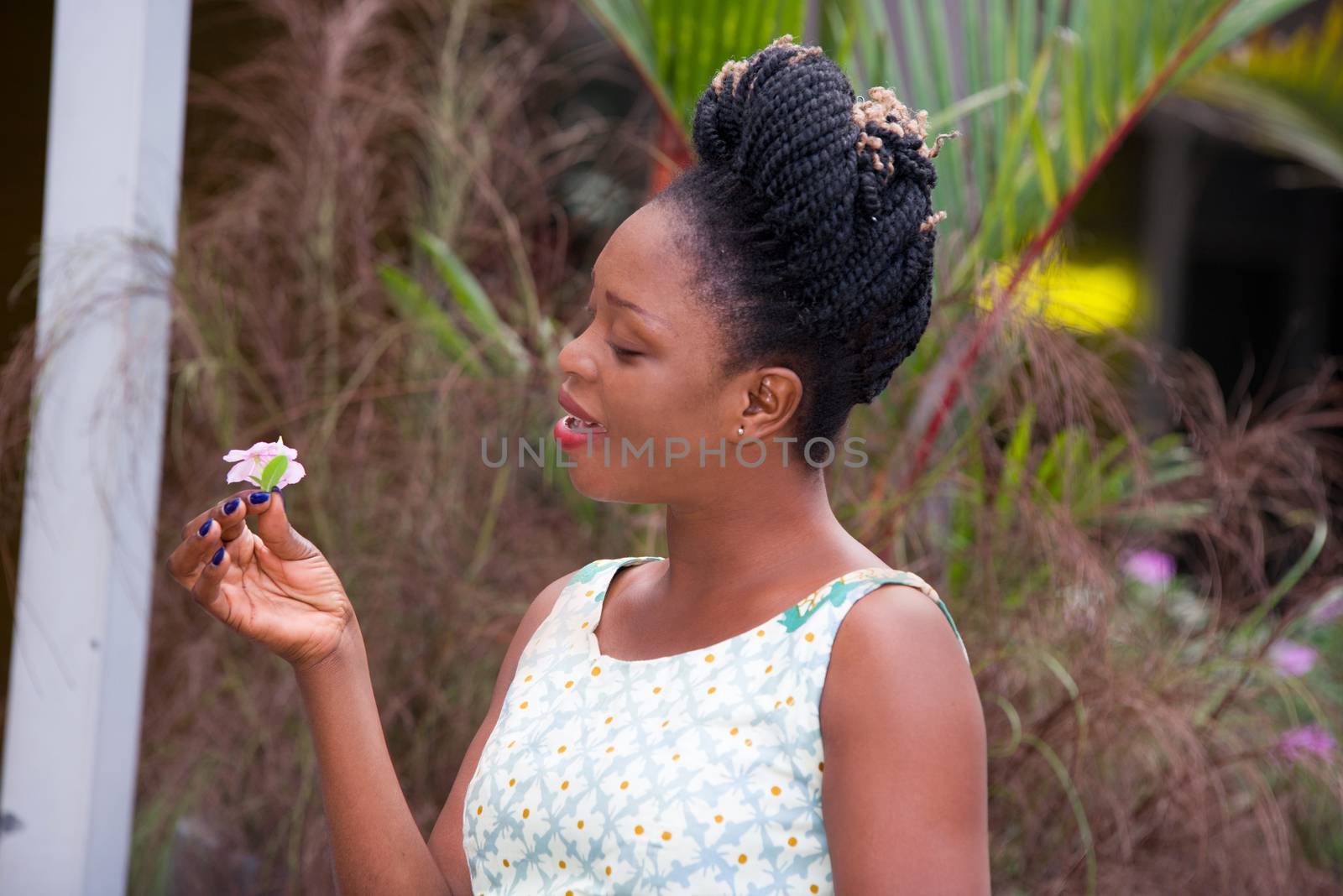 young happy businesswoman standing on the street and holding a white flower in the hand