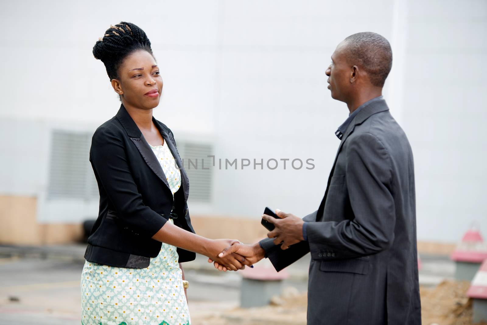 Handshake between a man and a businesswoman meeting in the street