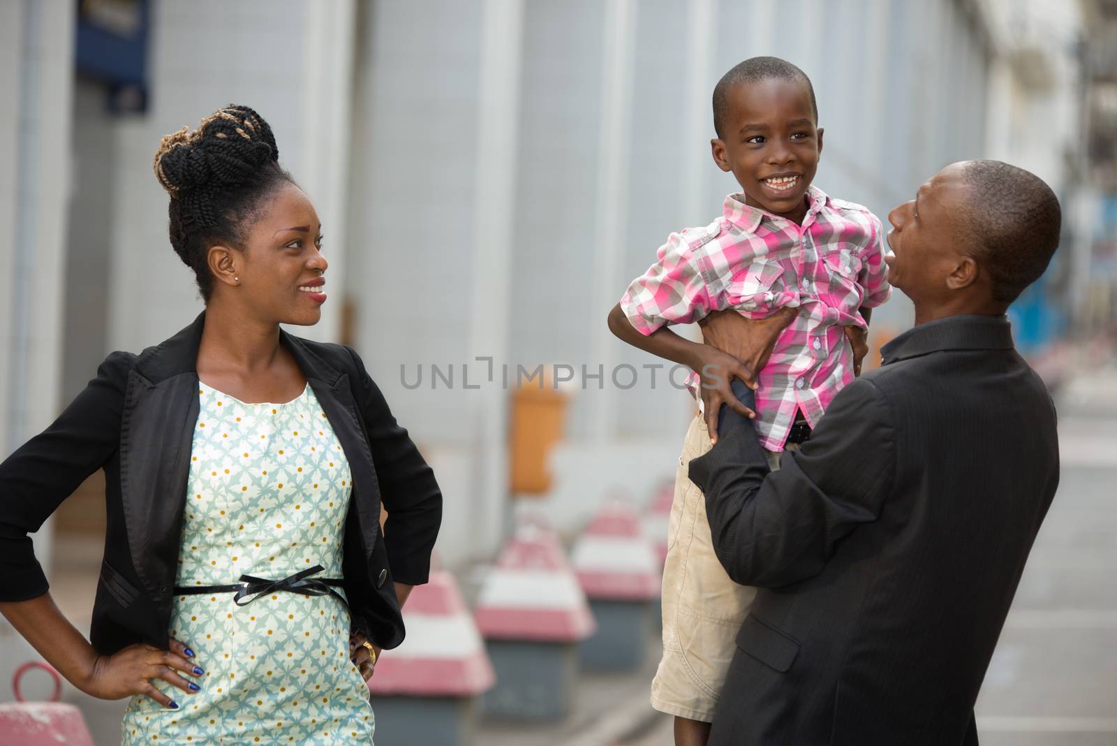 young happy couple with their child playing together on the street