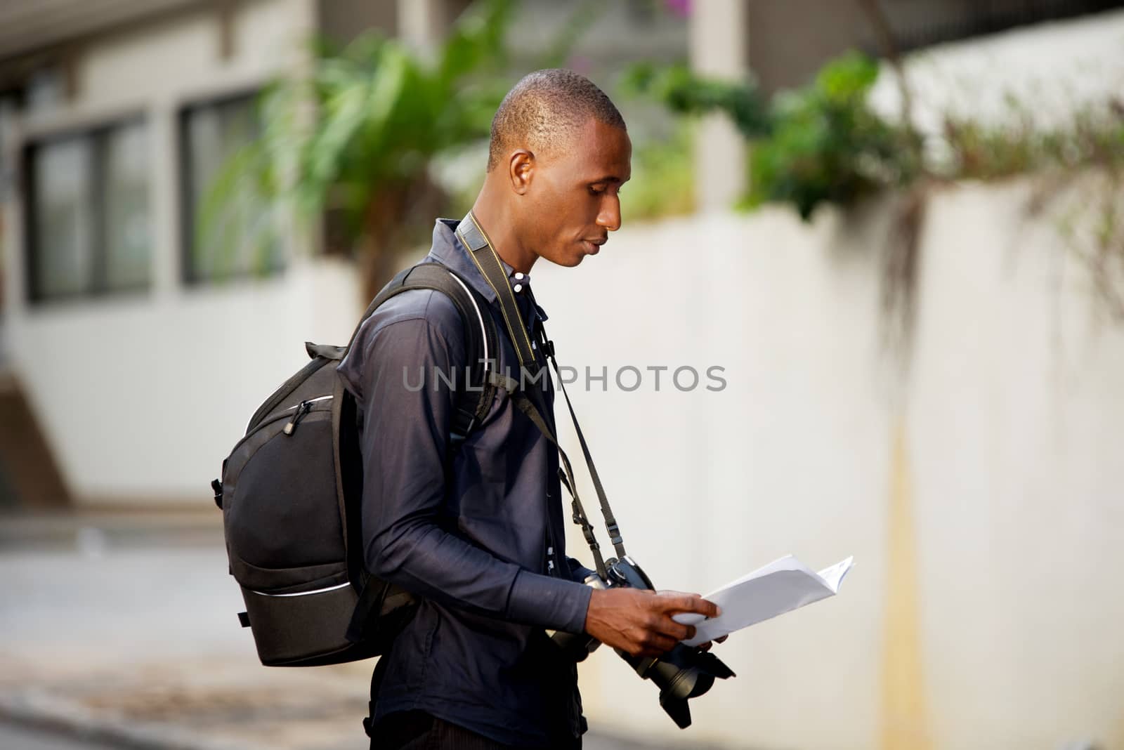 tourist man with map in hands explores the city in search of adventures.