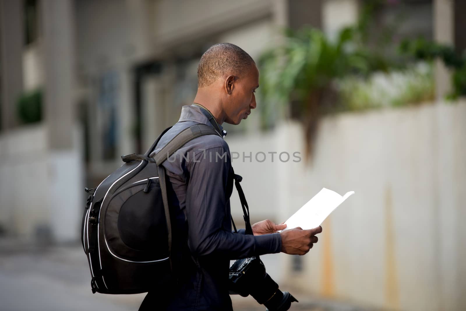 tourist man with map in hands explores the city in search of adventures.