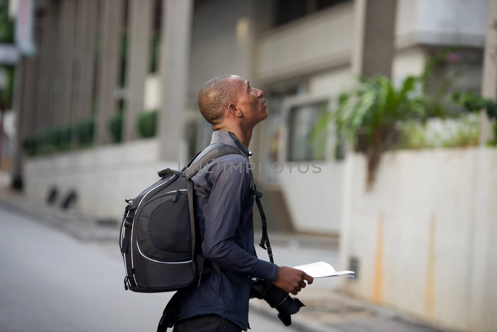 tourist man with map in hands explores the city in search of adventures.