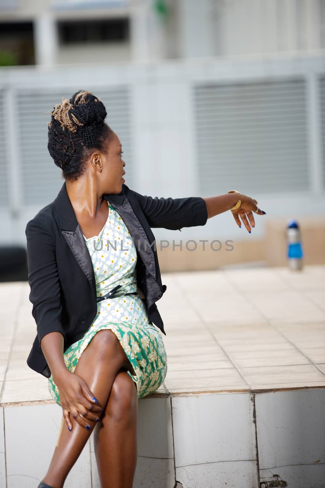 portrait of a woman sitting alone outside shows a place in front of a building