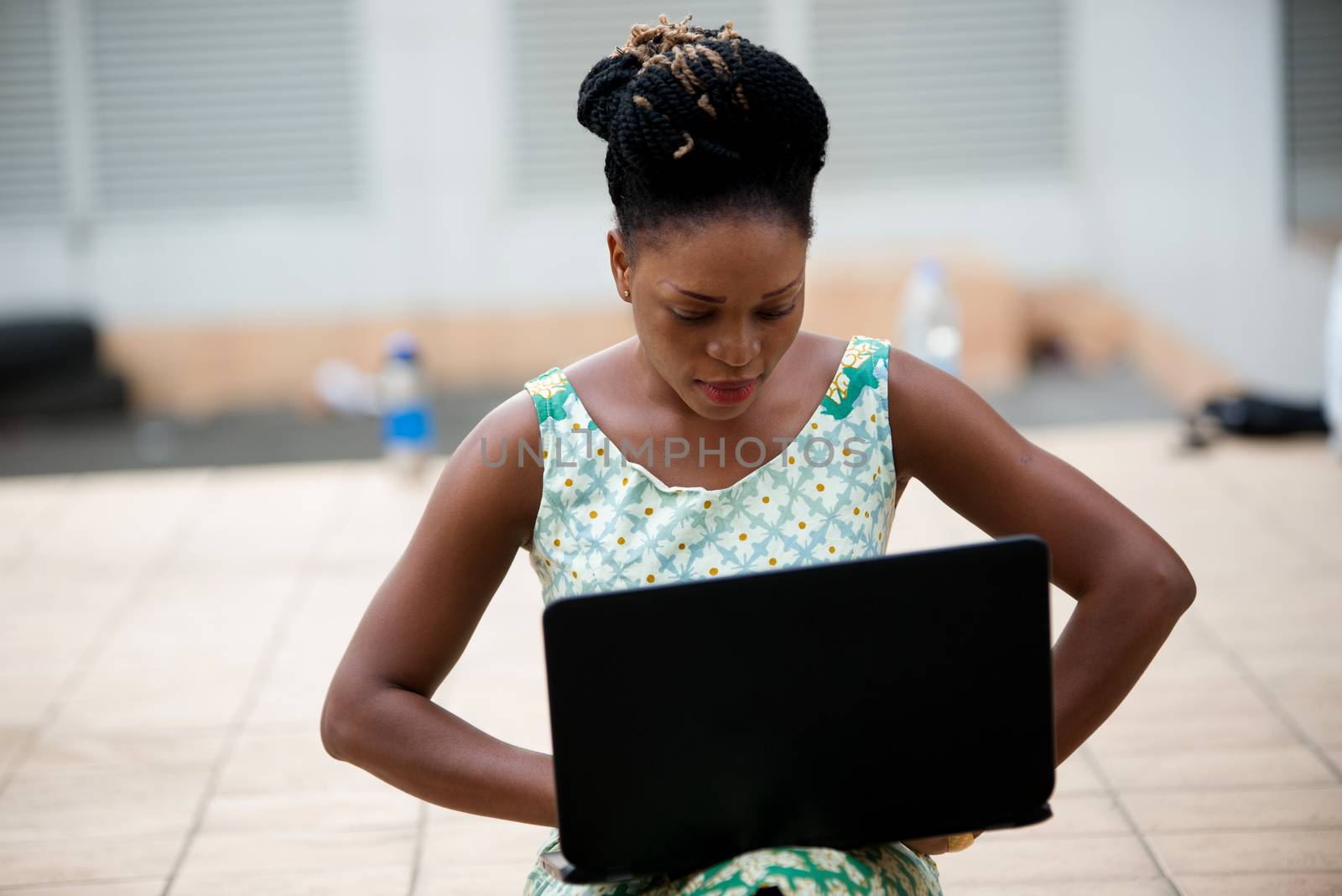 Close up of woman working on laptop sitting outdoors