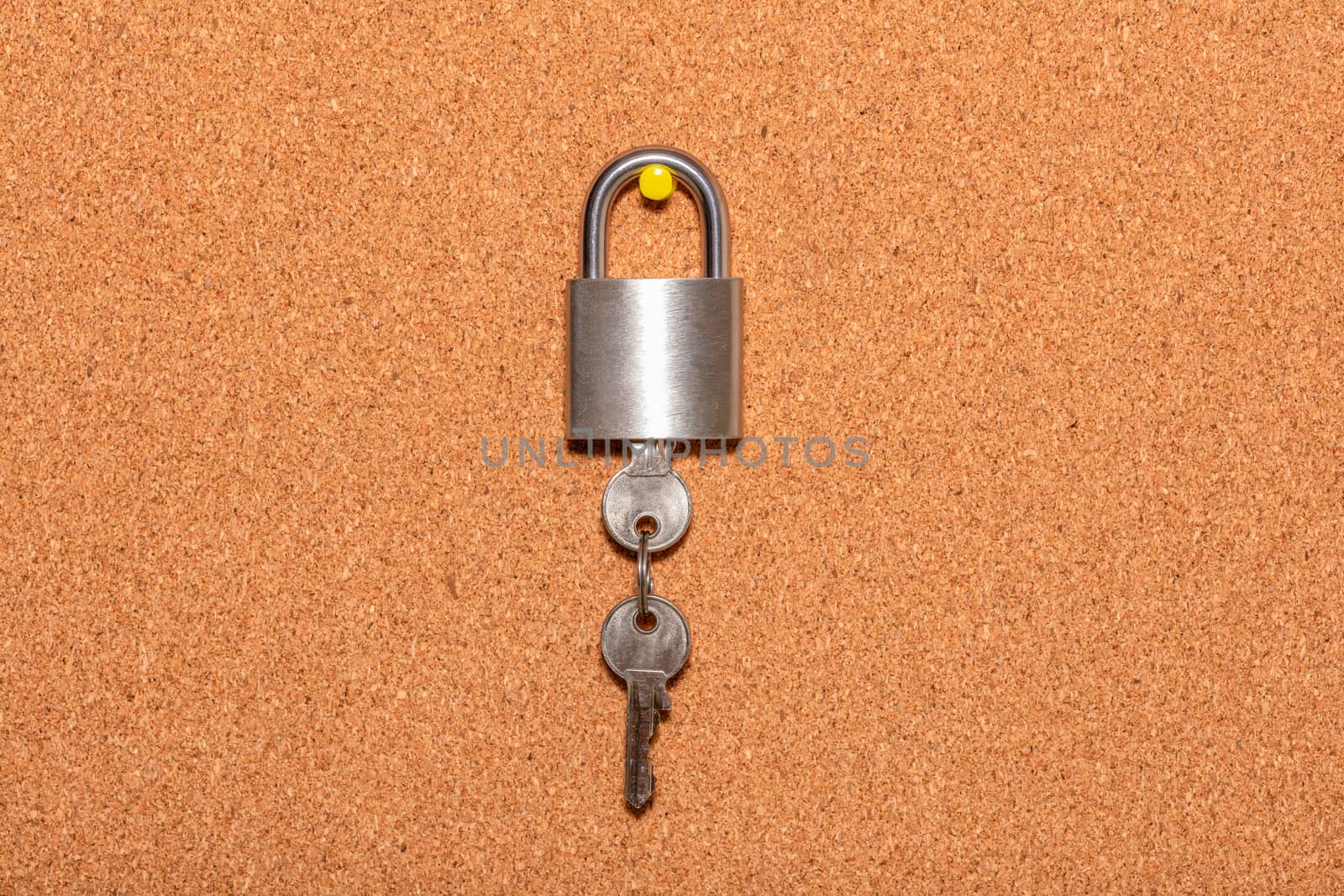 Closed padlock with keys hanging from it on an empty corkwood notice board in business office. Safety and security reminder, business closure, business for sale concepts. by DamantisZ