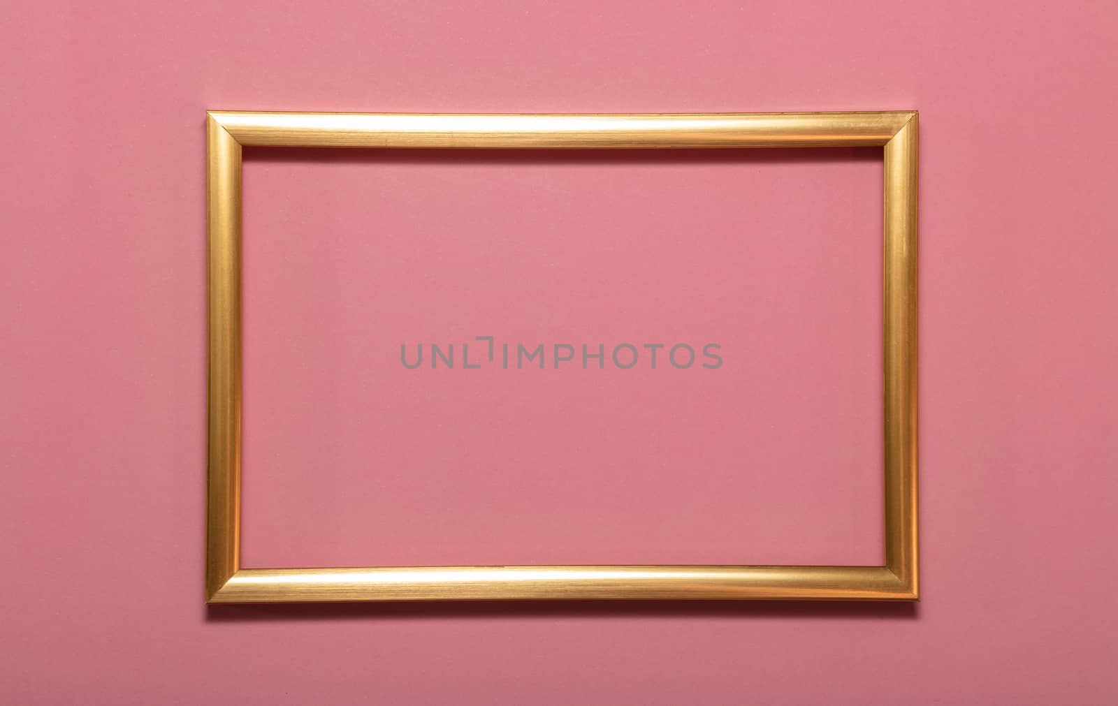 Golden empty frame picture on pink background . Copy space for text. Holiday card concept. Mock up. Greeting. Mother's Day. St Valentine's Day. Love and devotion concepts.