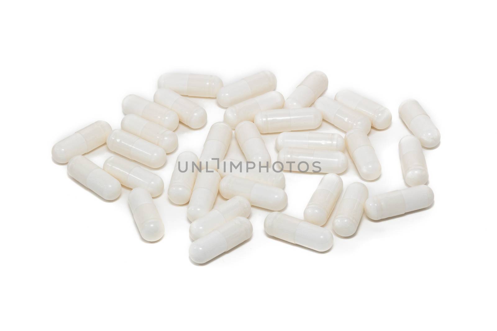 High angle close up shot of white pills isolated on white background. Pharmaceutical business and medicine sale concepts.