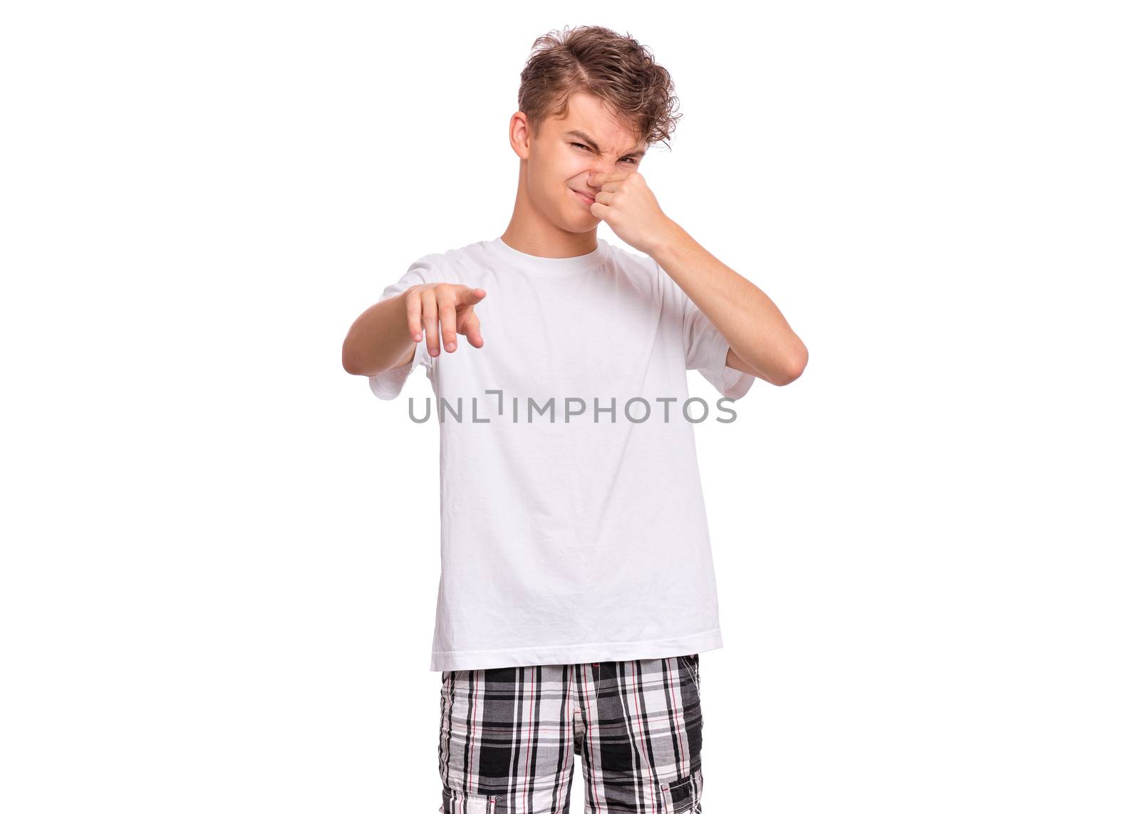 Handsome teen boy closes his nose from an unpleasant smell, isolated on white background