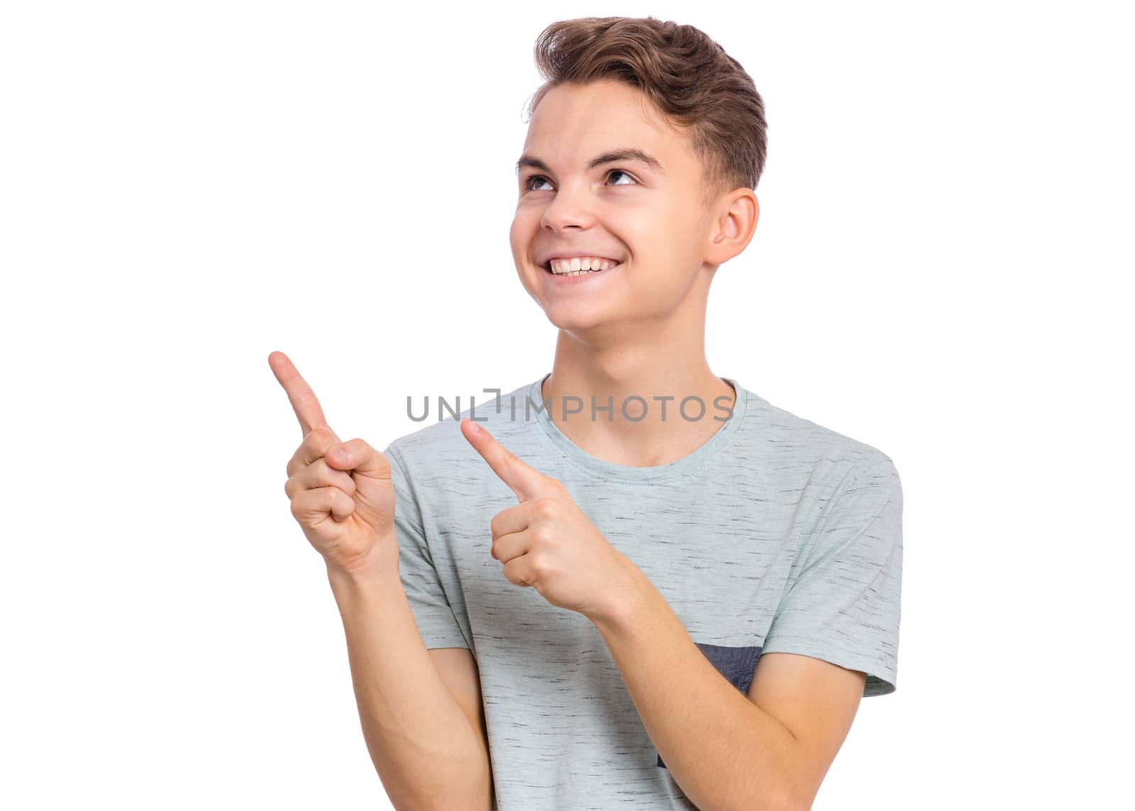 Cute teen boy pointing up, gesturing idea or doing number one gesture, isolated on white background