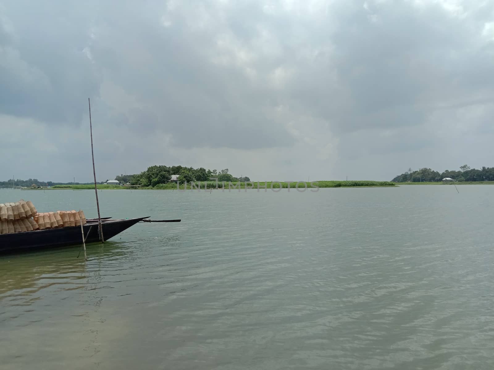 black colored wooden boat on river with sky