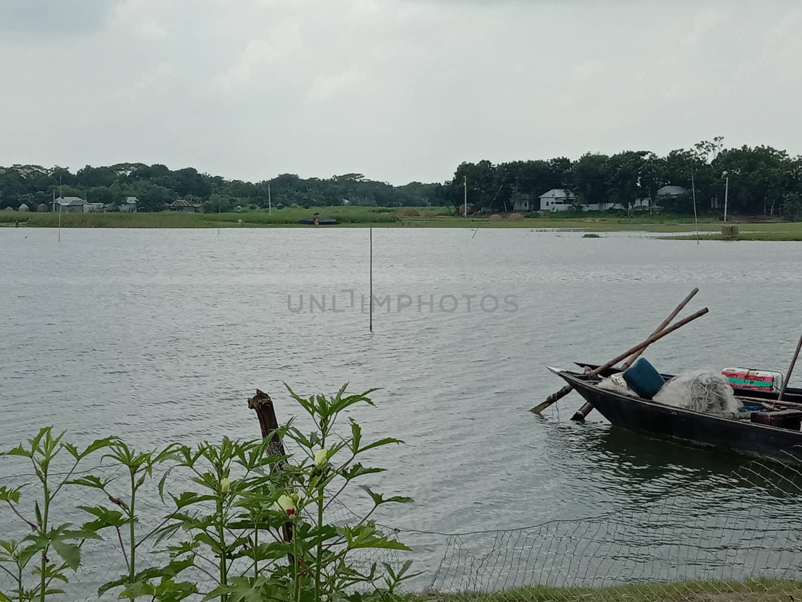 black colored wooden boat on river with nature
