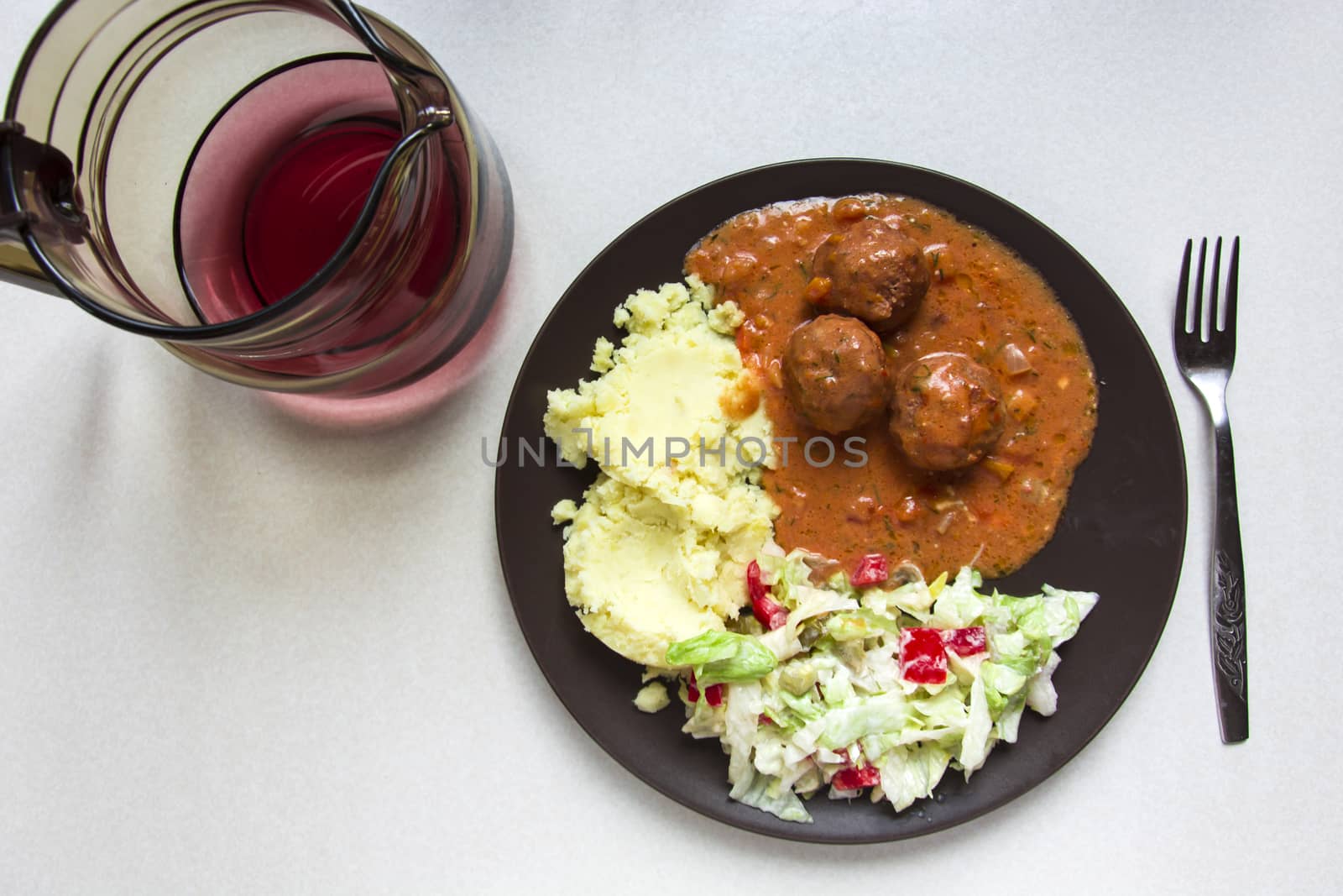 Dish with meatballs and compote in a jug, top view