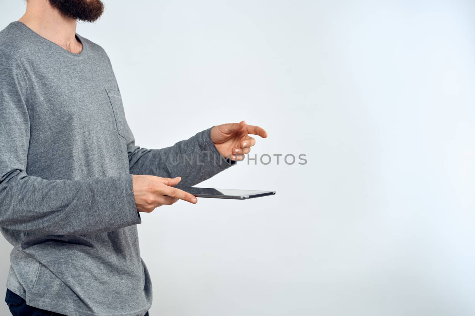 Man with tablet in hands technology lifestyle internet communication work light background cropped view. High quality photo